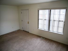Midland townhouse for rent - A room with a carpeted floor, a door, and a window with blinds.