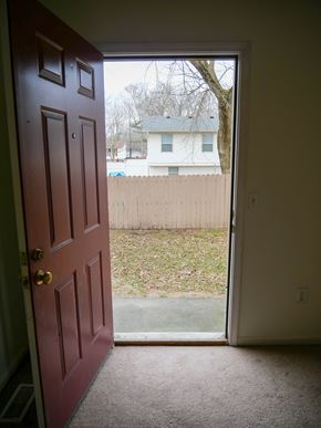 Midland townhouse for rent - A red door is open to a backyard.