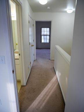 Midland townhouse for rent - A hallway with a carpeted floor and white walls.