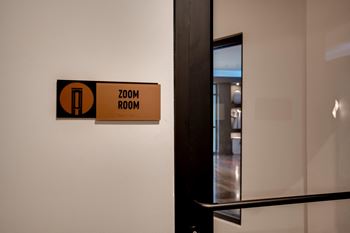 A door to a room with a zoom room sign on the wall
