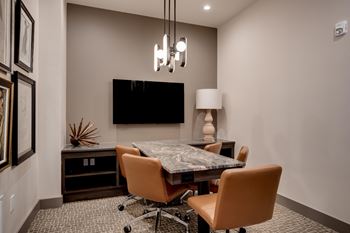 A conference room with a table and chairs and a tv