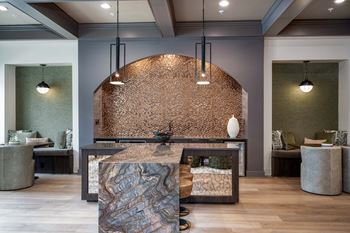 A reception area with a marble reception desk and two lamps