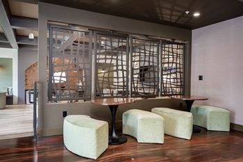 A room with a table and stools in front of a glass window