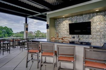 A bar and seating area with a television on the wall