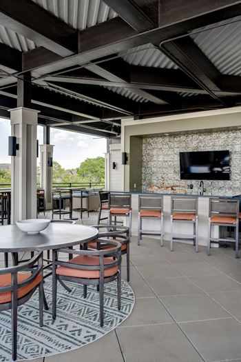 A patio with tables and chairs and a television