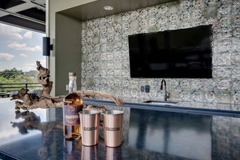 A bar with two glasses and a bottle of whiskey on it
