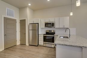 Augusta apartment for rent - Kitchen with stainless steel appliances and white cabinets at The Augustan, Augusta, Georgia