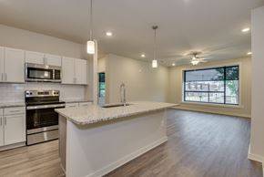 Augusta apartment for rent - an open kitchen and living room with a granite counter top at The Augustan, Georgia