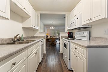 Augusta townhouse for rent - A kitchen with white cabinets and a wooden floor.