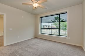 Augusta apartment for rent - an empty living room with a large window and a ceiling fan at The Augustan, Augusta