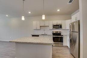 Augusta apartment for rent - a kitchen with stainless steel appliances and a granite counter top at The Augustan, Georgia, 30901