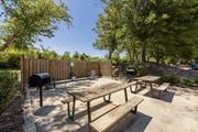 Augusta townhouse for rent - A wooden picnic table with benches is set in a sandy area with trees and a wooden fence in the background.