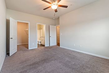A room with a ceiling fan and carpeted floor