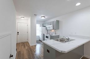 Grovetown apartment for rent - Kitchen area with white appliances and hallway leading to front door at Sterlington Apartments, Georgia, 30813