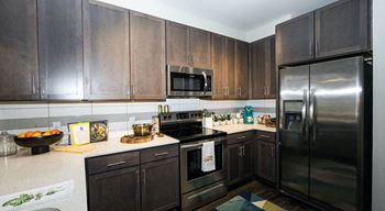 A kitchen with dark wood cabinets and stainless steel appliances.