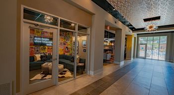 A hallway with a glass door leading to a room with a sign that says