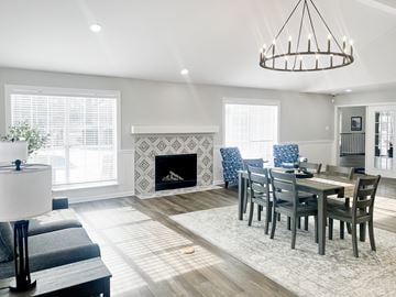 Glen Allen apartment for rent - A modern living room with a fireplace and a dining table set up.