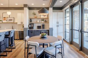 Westminster apartment for rent - A modern kitchen with a dining table set for four. at Arbour Commons, Westminster, CO