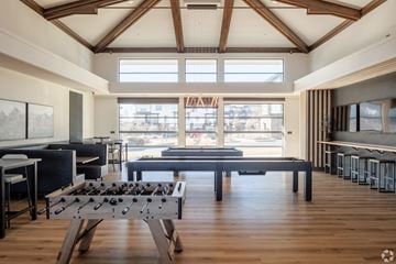Westminster apartment for rent - A modern living room with a foosball table in the center.