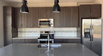 A modern kitchen with a stainless steel refrigerator and a central island
