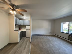 Milwaukee apartment for rent - an empty living room with a ceiling fan and a kitchen