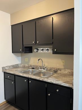 New Berlin apartment for rent - A kitchen with black cabinets and a granite countertop.
