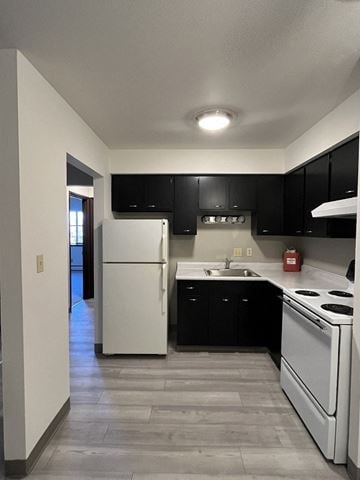 Milwaukee apartment for rent - a kitchen with white appliances and black cabinets