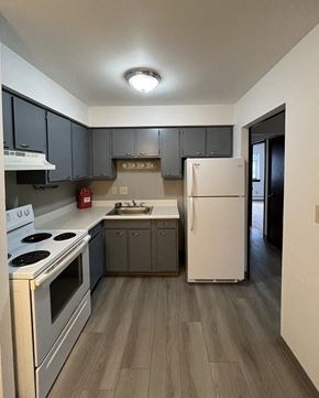 Milwaukee apartment for rent - a kitchen with white appliances and gray cabinets