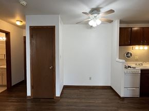 Milwaukee apartment for rent - an empty living room with a ceiling fan and a kitchen