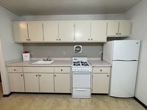 Milwaukee apartment for rent - a kitchen with white appliances and white cabinets and a refrigerator