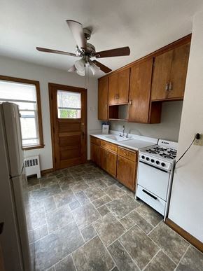 Milwaukee apartment for rent - an empty kitchen with a ceiling fan and a refrigerator