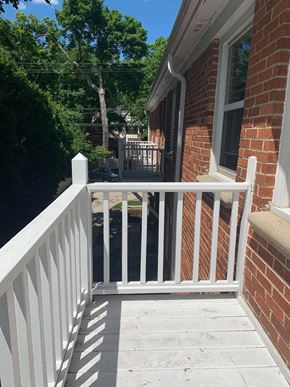 Milwaukee apartment for rent - a small porch with a white railing and a brick building