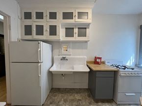 Milwaukee apartment for rent - a kitchen with white cabinets and a sink and a refrigerator