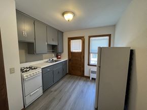 Milwaukee apartment for rent - an empty kitchen with white appliances and gray cabinets