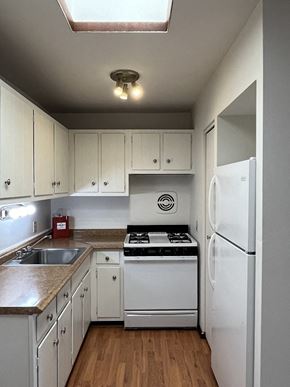 Milwaukee apartment for rent - A small kitchen with white appliances and cabinets.