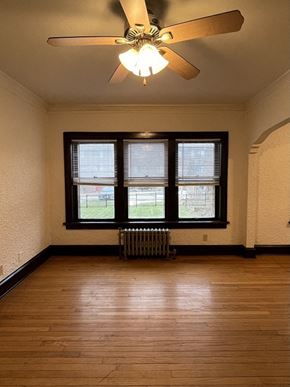 Milwaukee apartment for rent - an empty living room with a ceiling fan and a window