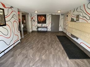 Milwaukee apartment for rent - the lobby of a gym with a dance floor and a wall with a painting on