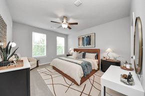 Spring apartment for rent - A bedroom with a king sized bed, night stand, dresser and a ceiling fan.