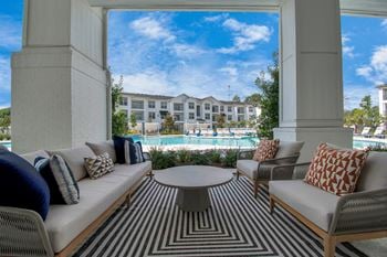 Luxurious poolside covered patio with soft seating