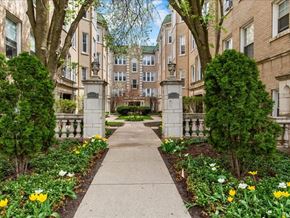 Chicago apartment for rent - A pathway with a white fence and yellow flowers on the sides.