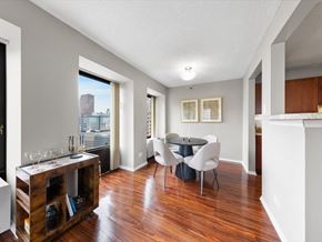 Chicago apartment for rent - A dining room with a table set for two and a view of a city skyline.