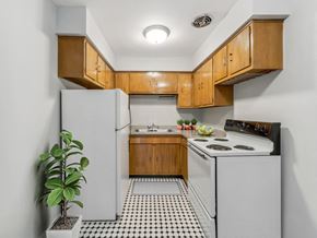 Chicago apartment for rent - a kitchen with white appliances and wooden cabinets