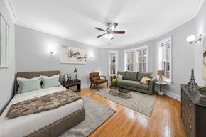 Chicago apartment for rent - a bedroom with a bed and a couch and a ceiling fan