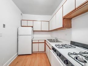 Chicago apartment for rent - a kitchen with white cabinets and white appliances