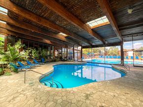 Hoffman Estates apartment for rent - A large indoor swimming pool with a wooden ceiling and tiled floor.