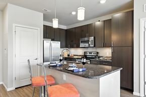 Des Peres apartment for rent - A kitchen with a white counter top and a refrigerator at Alinea Town and Country Luxury Apartments in Des Peres MO 63131.