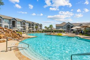 San Antonio apartment for rent - A large swimming pool in front of a resort-style building.