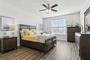 O'fallon apartment for rent - A bedroom with a bed, dresser, and nightstand at Bramblett Hills Luxury Apartments in O Fallon MO 63366