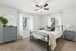 Ballwin apartment for rent - A bedroom with a bed, dresser, and window.