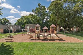 Ballwin apartment for rent - A playground with a slide, swings, and a sandbox.